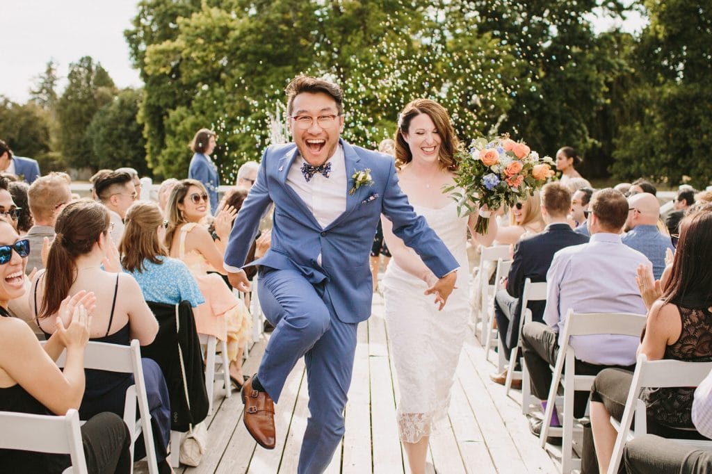 Excited bride and groom exit ceremony at Vancouver Rowing Club